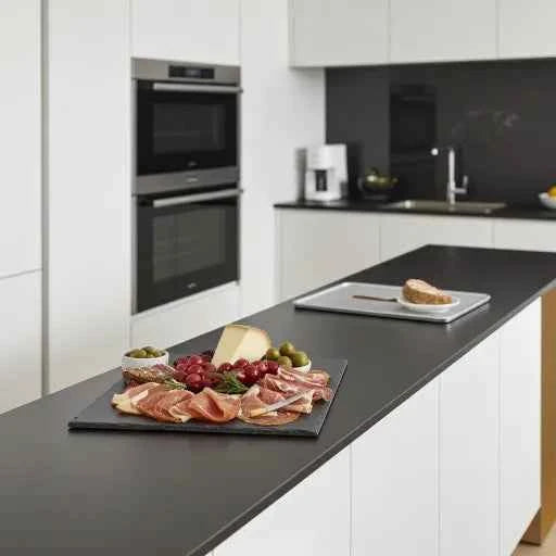 Cutting board with cheese, sausage, and grapes in a modern kitchen – sustainable & high quality